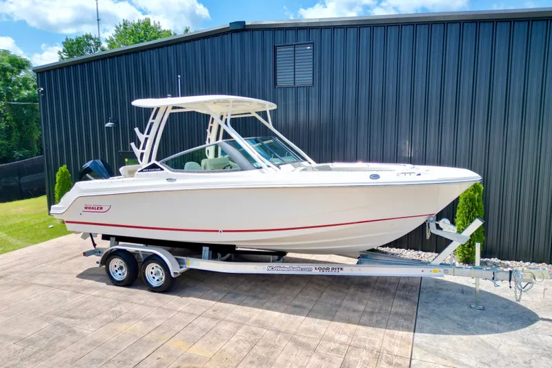 Slide: The Image of 2025 Boston Whaler 240 Vantage boat on trailer, parked outdoors. - 1