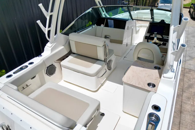 Slide: The Image of 2025 Boston Whaler 240 Vantage boat interior with seating and helm, showcasing luxury design. - 12