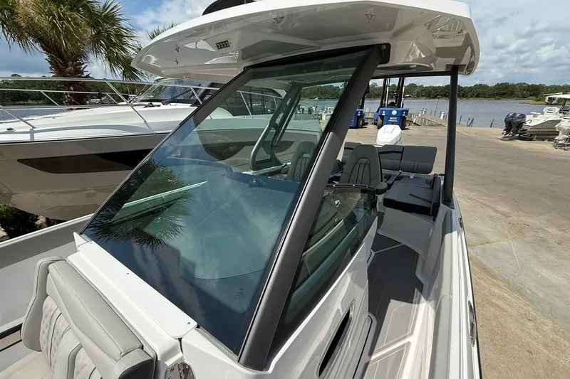 Slide: The Image of 2027 Monterey Elite 27 OB boat docked, showcasing sleek design and spacious seating. - 15