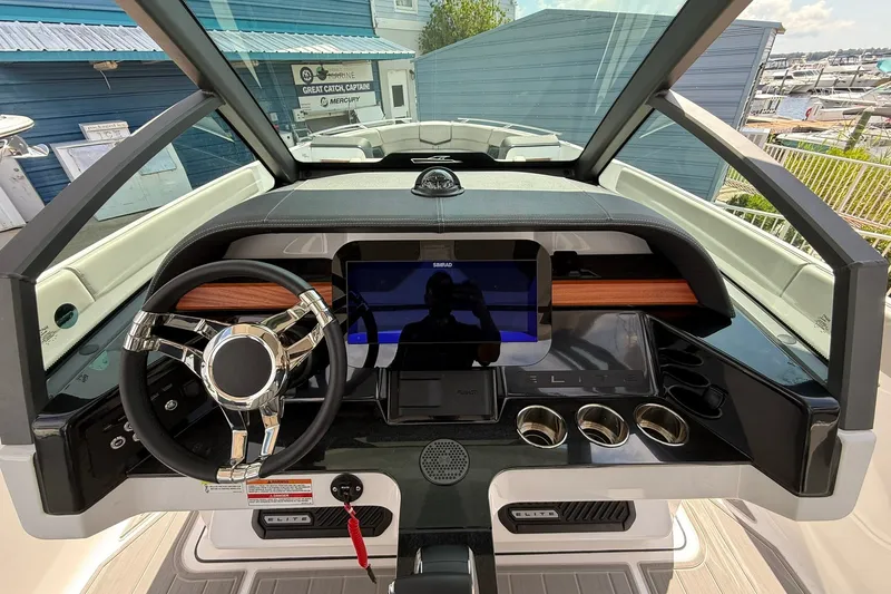Slide: The Image of Cockpit of 2027 Monterey Elite 27 OB boat with modern steering and dashboard controls. - 18