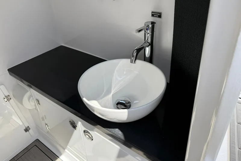 Slide: The Image of Modern sink in 2027 Monterey Elite 27 OB boat, featuring sleek design and chrome faucet. - 13
