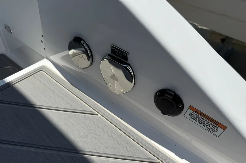Slide: The Image of 2027 Monterey Elite 27 OB boat deck with non-potable water access and warning label. - 27