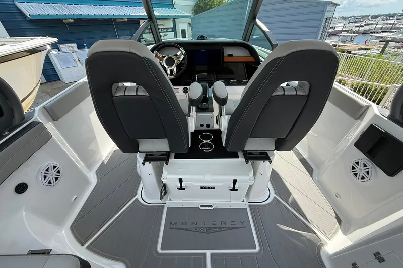 Slide: The Image of Interior view of 2027 Monterey Elite 27 OB boat cockpit with dual seats and steering wheel. - 20