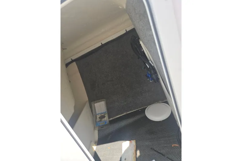 Slide: The Image of Interior storage compartment of 2022 Chaparral 23 SSi boat, featuring carpeted walls. - 17