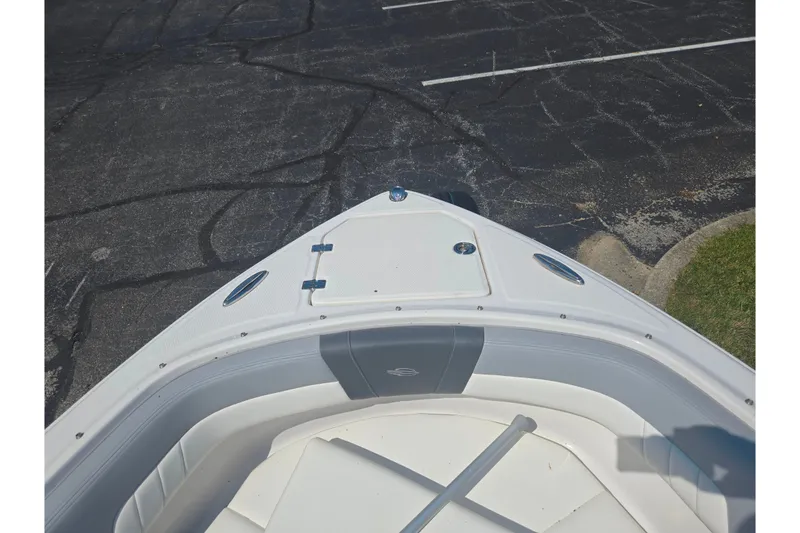 Slide: The Image of 2022 Chaparral 23 SSi boat bow with white seating and storage compartment. - 19