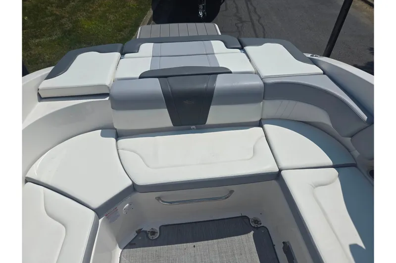 Slide: The Image of 2022 Chaparral 23 SSi boat interior with white and gray cushioned seating. - 23