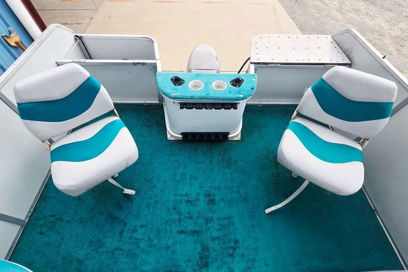 Slide: The Image of 1998 Sun Tracker Fishin' Barge 21 interior with teal and white seating. - 20