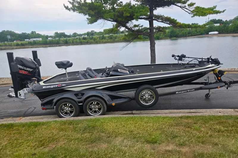 Slide: The Image of 2016 Ranger Z521 Comanche boat on trailer by a lakeside road. - 10