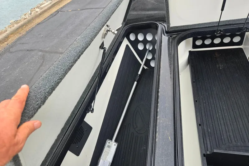 Slide: The Image of 2016 Ranger Z521 Comanche boat storage compartment with open lid and organized interior. - 16