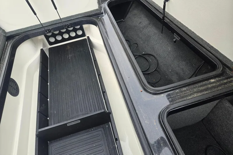 Slide: The Image of 2016 Ranger Z521 Comanche boat storage compartments with open lids and organized interior. - 15