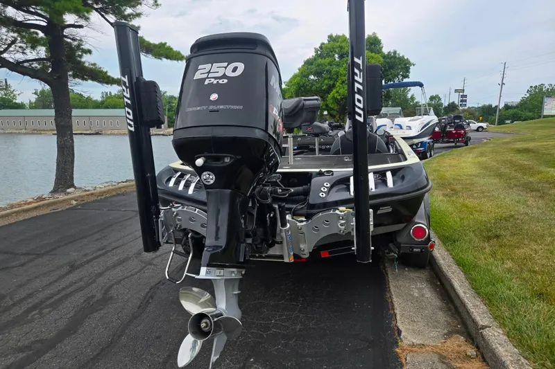 Slide: The Image of 2016 Ranger Z521 Comanche boat with 250 Pro motor, parked near a lake. - 2
