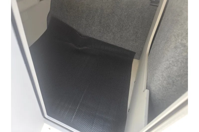 Slide: The Image of Interior storage compartment of 2023 Chaparral 21 SSi boat with black mat. - 18