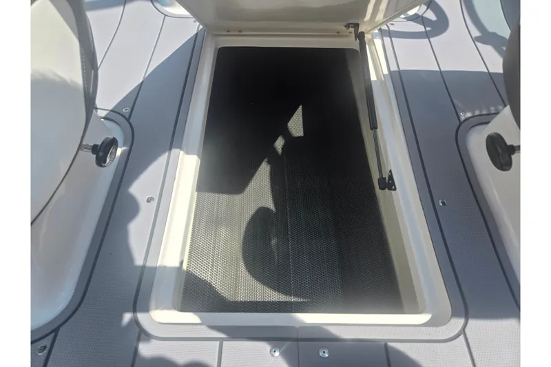 Slide: The Image of 2023 Chaparral 21 SSi boat storage compartment with open hatch and textured flooring. - 14
