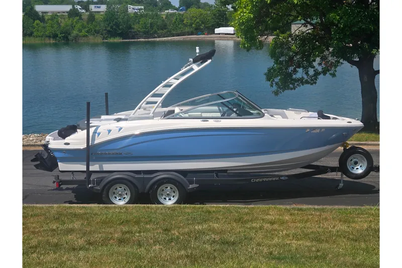 The Image of 2023 Chaparral 21 SSi boat on trailer by a lake, side view. - 0