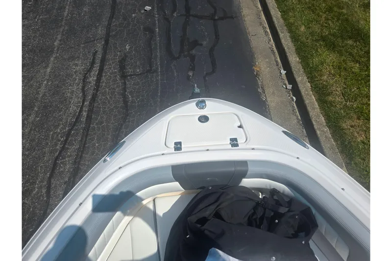 Slide: The Image of 2023 Chaparral 21 SSi boat bow view on pavement, showcasing sleek design. - 20