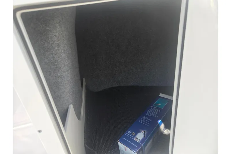 Slide: The Image of Storage compartment in 2023 Chaparral 21 SSi boat with a box inside. - 17
