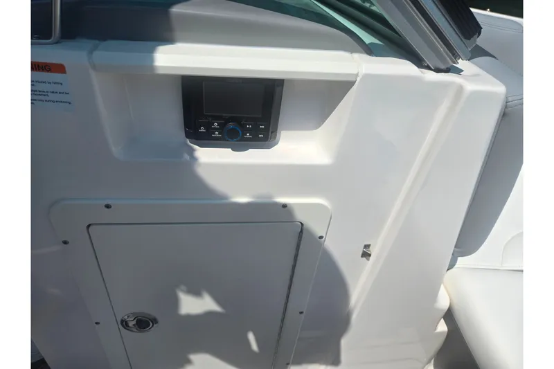 Slide: The Image of 2023 Chaparral 21 SSi boat interior with control panel and storage compartment. - 16