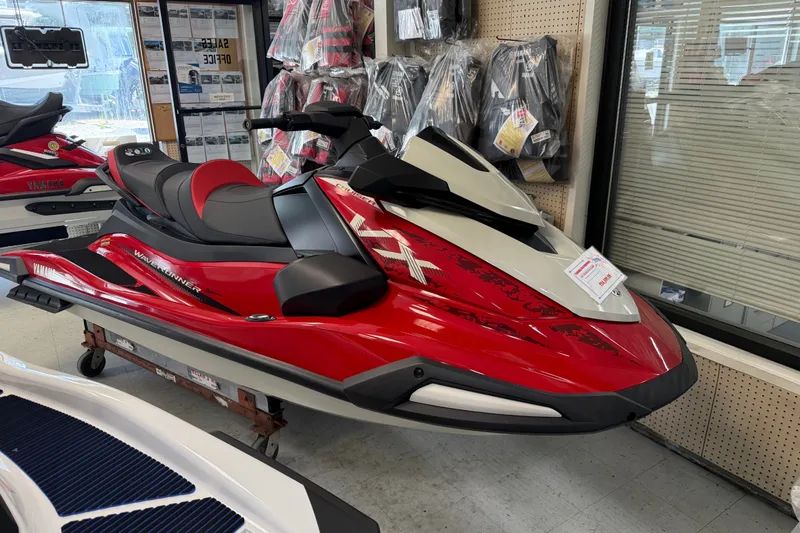 The Image of 2026 Yamaha WaveRunner VX Cruiser in showroom, red and black design, displayed indoors. - 0