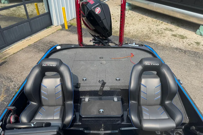 Slide: The Image of 2022 Nitro Z20 boat interior with dual seats and motor, parked outdoors. - 9