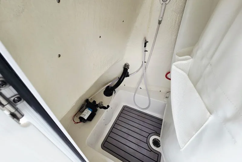 Slide: The Image of 2024 Tidewater 210 LXF boat interior shower area with pump and hose. - 9