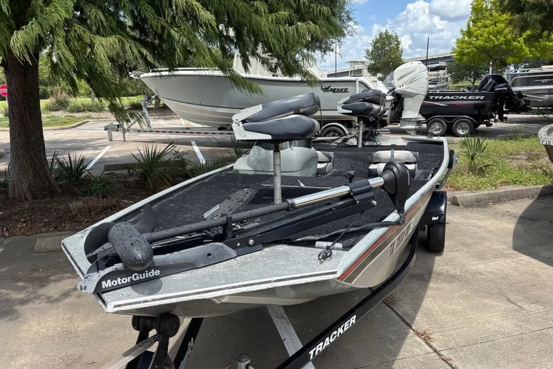 Slide: The Image of 2012 Tracker Pro 165 fishing boat with MotorGuide trolling motor in a parking lot. - 19