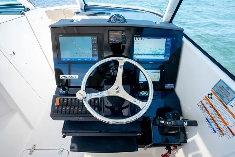 Slide: The Image of Cockpit of 2018 Pursuit DC 325 Dual Console with steering wheel and navigation screens. - 16