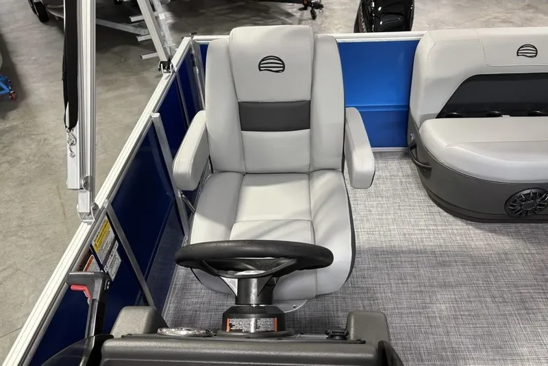 Slide: The Image of 2027 Sun Tracker Party Barge 16 DLX interior with gray seating and steering wheel. - 16