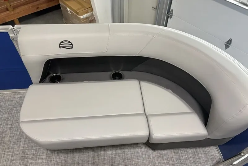 Slide: The Image of 2027 Sun Tracker Party Barge 16 DLX seating area with cup holders and gray upholstery. - 20