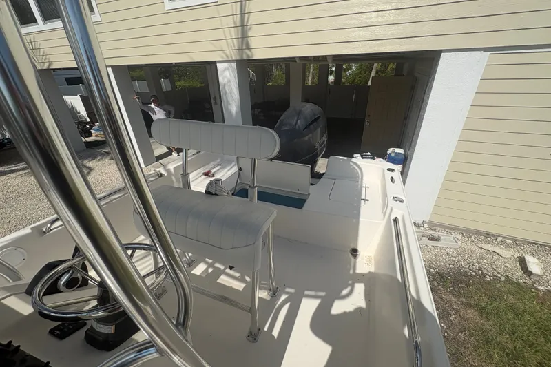 Slide: The Image of 2015 Bulls Bay 2200 boat with seating and outboard motor in a garage setting. - 12