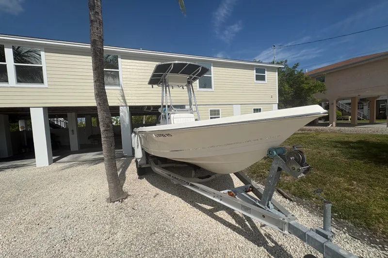 The Image of 2015 Bulls Bay 2200 boat on trailer, parked beside a house under a clear blue sky. - 1