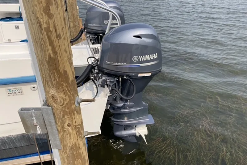 Slide: The Image of 1998 Kevlacat Series 2000 Cuddy Cabin with Yamaha outboard motor docked by water. - 11