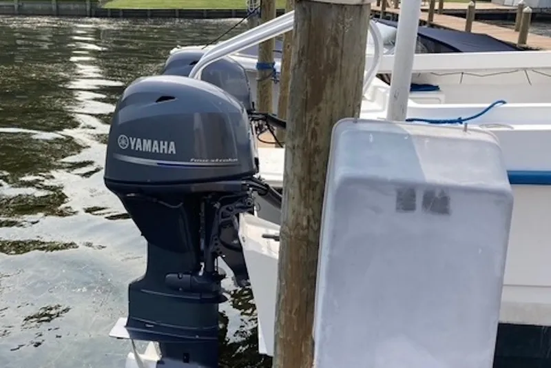 Slide: The Image of 1998 Kevlacat Series 2000 Cuddy Cabin with Yamaha outboard motor docked by water. - 10