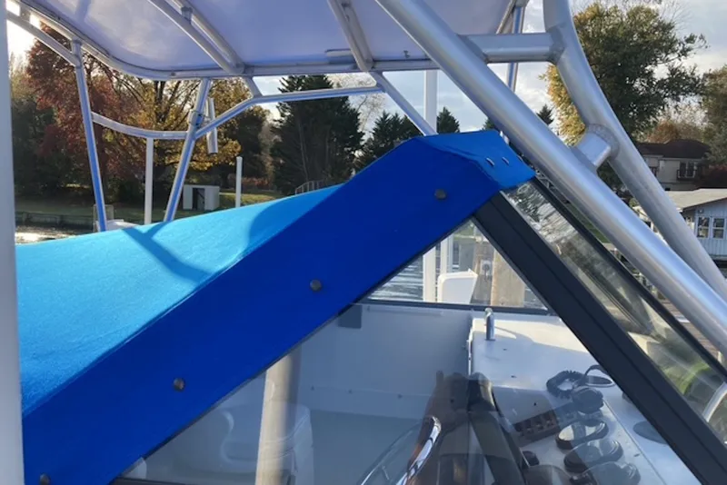 Slide: The Image of 1998 Kevlacat Series 2000 Cuddy Cabin OB with blue cover and steering console. - 8
