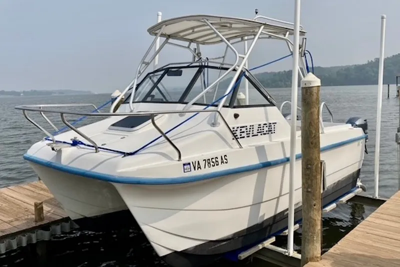 The Image of 1998 Kevlacat Series 2000 Cuddy Cabin OB docked by the water. - 1