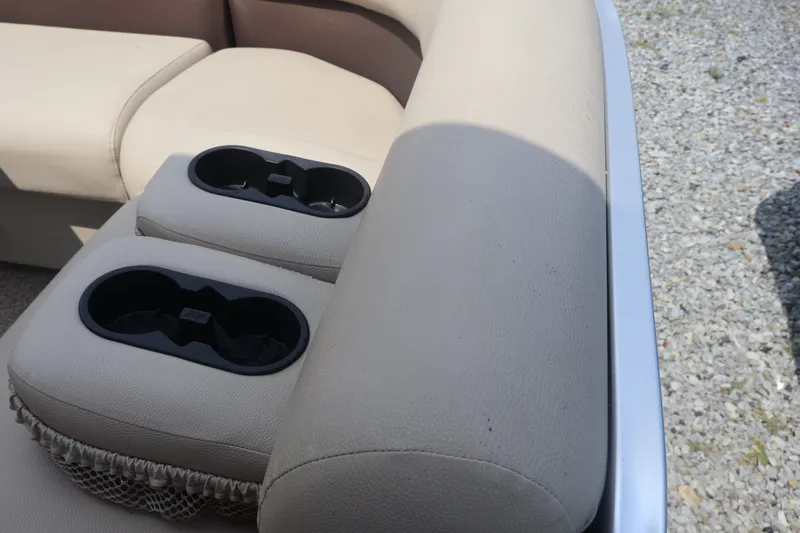 Slide: The Image of 2015 Palm Beach Ultra Sport 220 RL boat interior with beige seating and dual cup holders. - 15