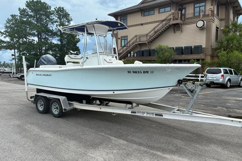 Slide: The Image of 2012 Sea Hunt Ultra 211 boat on trailer, parked near a building. - 16