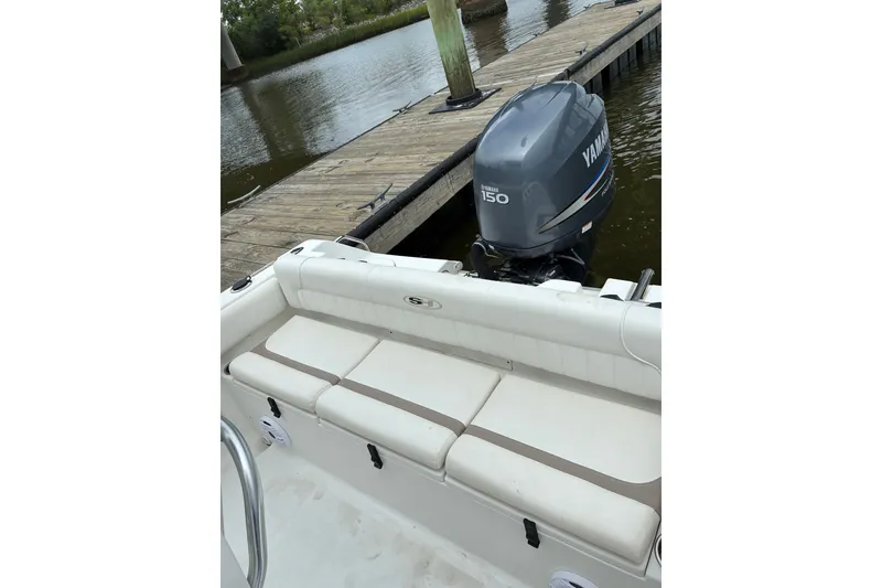 Slide: The Image of 2012 Sea Hunt Ultra 211 boat with Yamaha 150 engine docked by a wooden pier. - 14