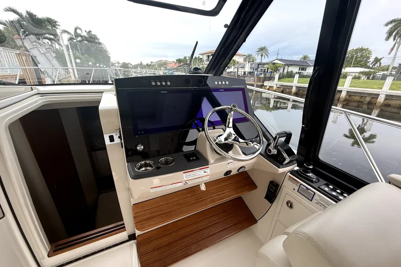 Slide: The Image of 2024 Boston Whaler 405 Conquest helm with modern controls and sleek design. - 18
