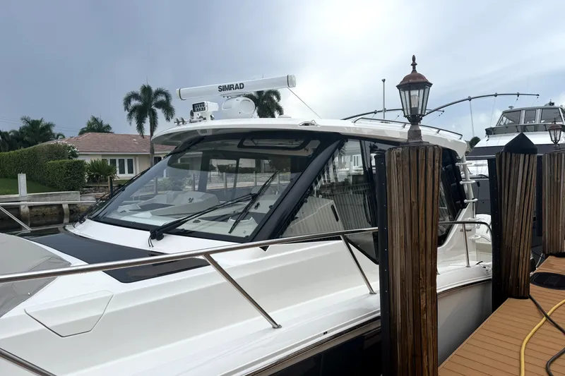 Slide: The Image of 2024 Boston Whaler 405 Conquest docked, showcasing sleek design and advanced navigation equipment. - 6
