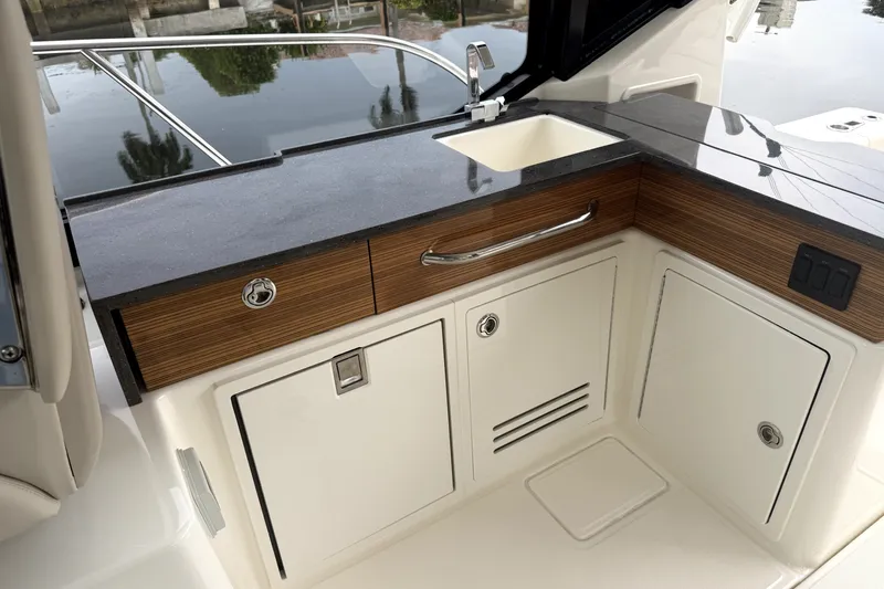 Slide: The Image of 2024 Boston Whaler 405 Conquest boat kitchenette with sink and storage cabinets. - 5