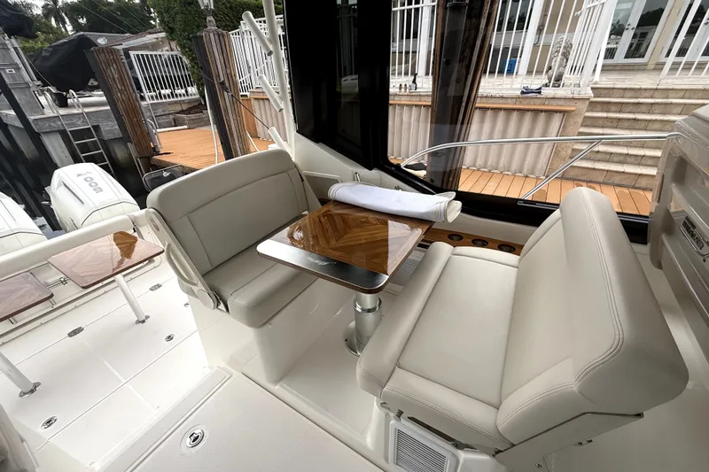 Slide: The Image of 2024 Boston Whaler 405 Conquest interior with plush seating and elegant table. - 26
