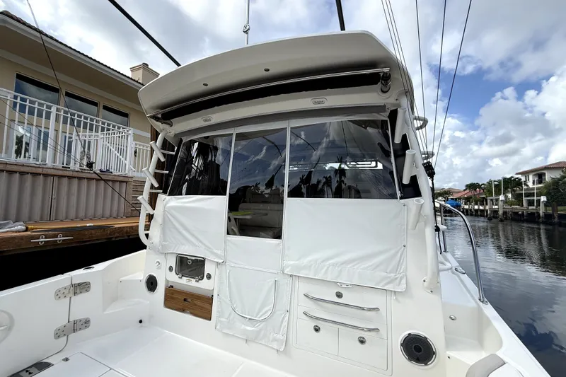 Slide: The Image of 2024 Boston Whaler 405 Conquest boat docked, showcasing rear deck and cabin entrance. - 9