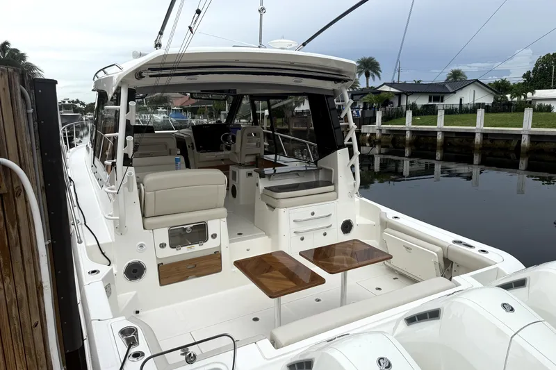 Slide: The Image of 2024 Boston Whaler 405 Conquest boat docked, showcasing spacious seating and sleek design. - 4