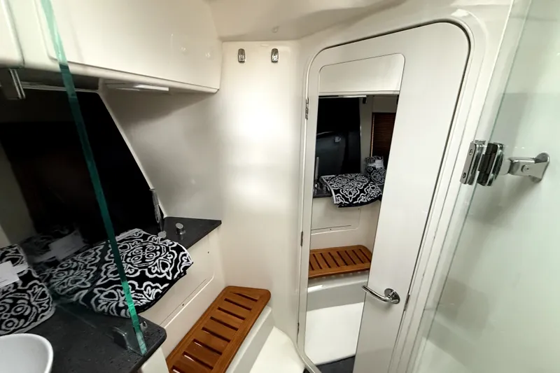 Slide: The Image of 2024 Boston Whaler 405 Conquest cabin interior with modern design and patterned cushions. - 11