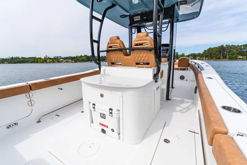 Slide: The Image of 2026 Sea Hunt Ultra 305SE boat interior with tan seating and Yamaha cooler on a calm lake. - 22