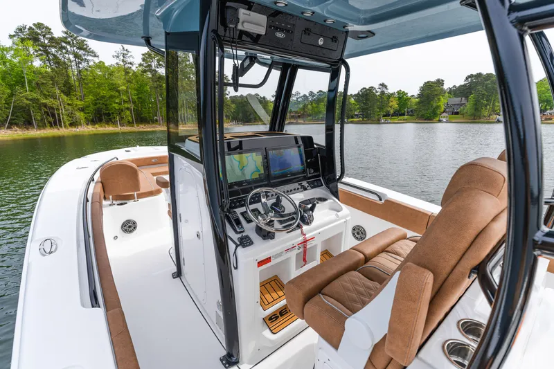 Slide: The Image of 2026 Sea Hunt Ultra 305SE boat interior with advanced navigation system on a serene lake. - 10