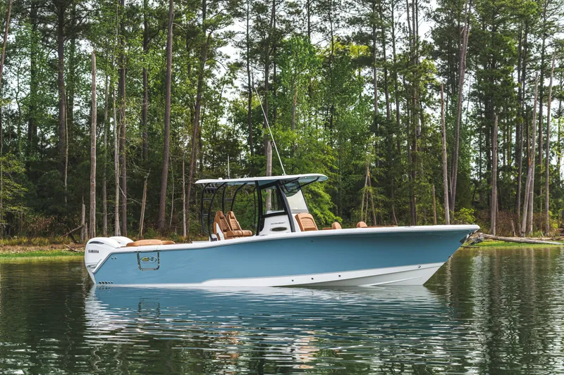 Slide: The Image of 2026 Sea Hunt Ultra 305SE boat on calm water, surrounded by lush trees. - 1