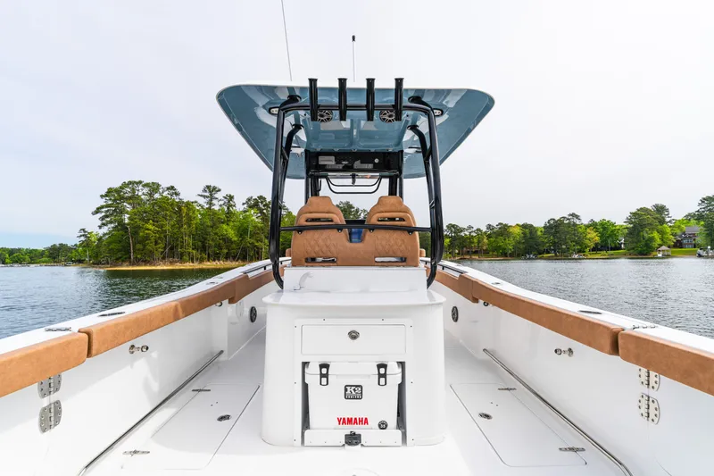 Slide: The Image of 2026 Sea Hunt Ultra 305SE boat interior with tan seating, on a serene lake. - 20