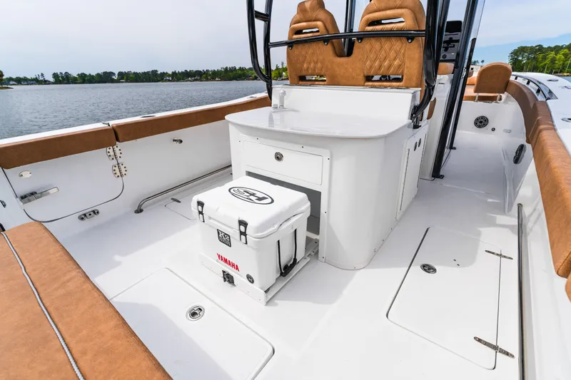 Slide: The Image of 2026 Sea Hunt Ultra 305SE boat interior with seating and storage, on a calm lake. - 23