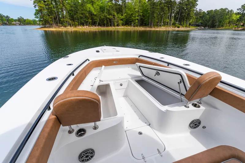 Slide: The Image of 2026 Sea Hunt Ultra 305SE boat interior with open storage, brown seating, and scenic lake view. - 27